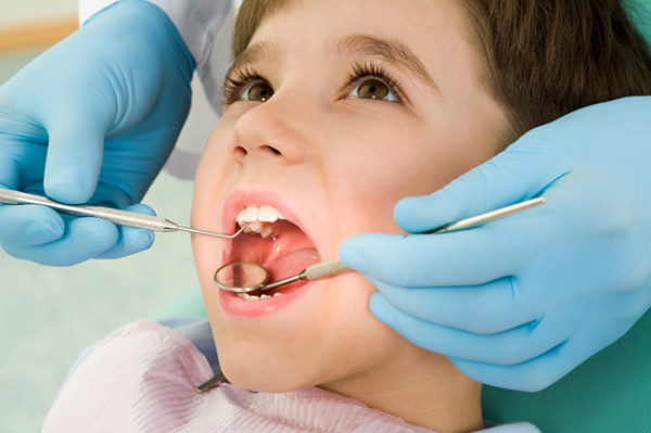 tandläkare undersöker pojke