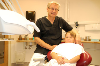 Tandläkare Gert Oxby på nya kliniken tillsammans med barnbarn.